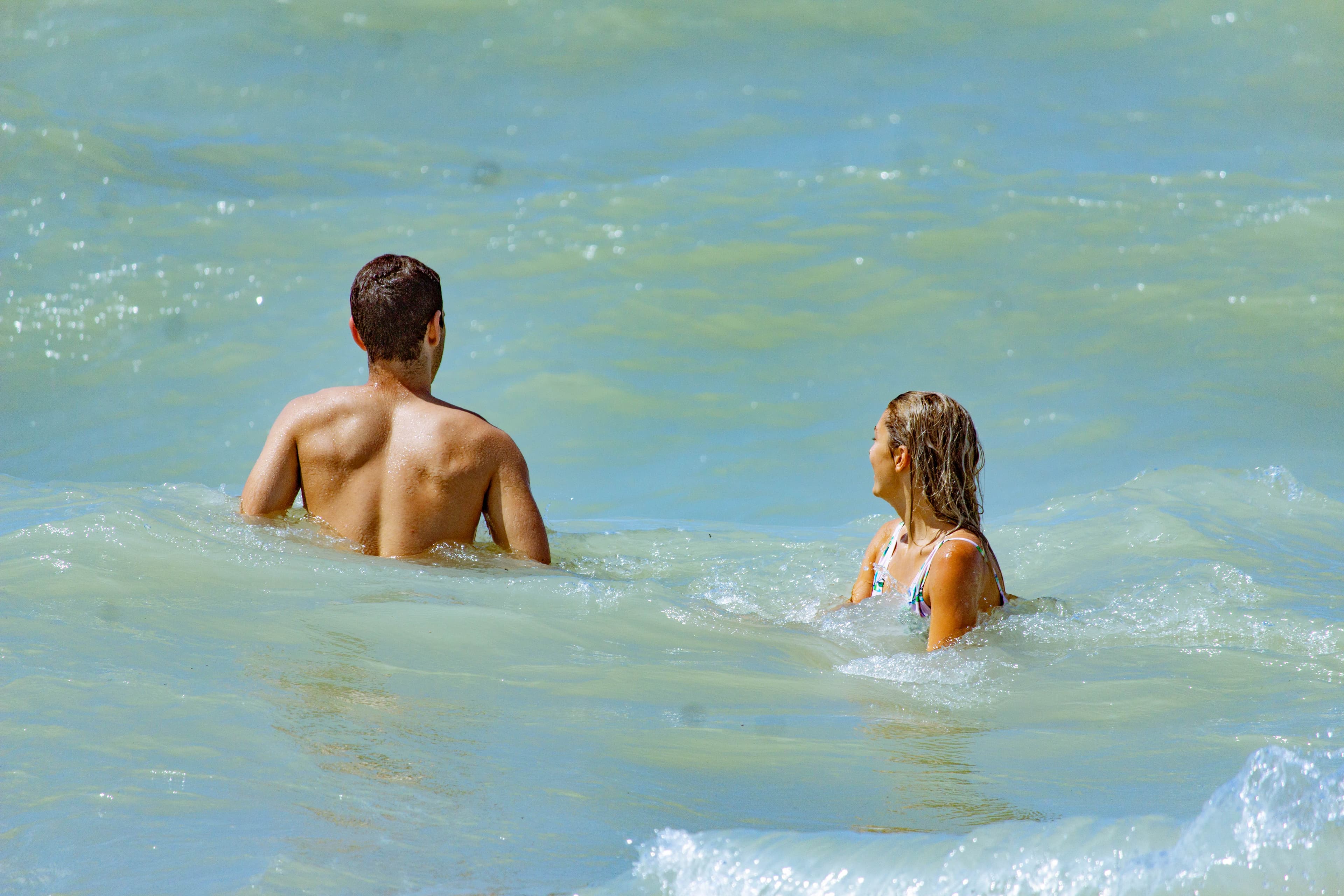 A man and a woman in the water at a beach
