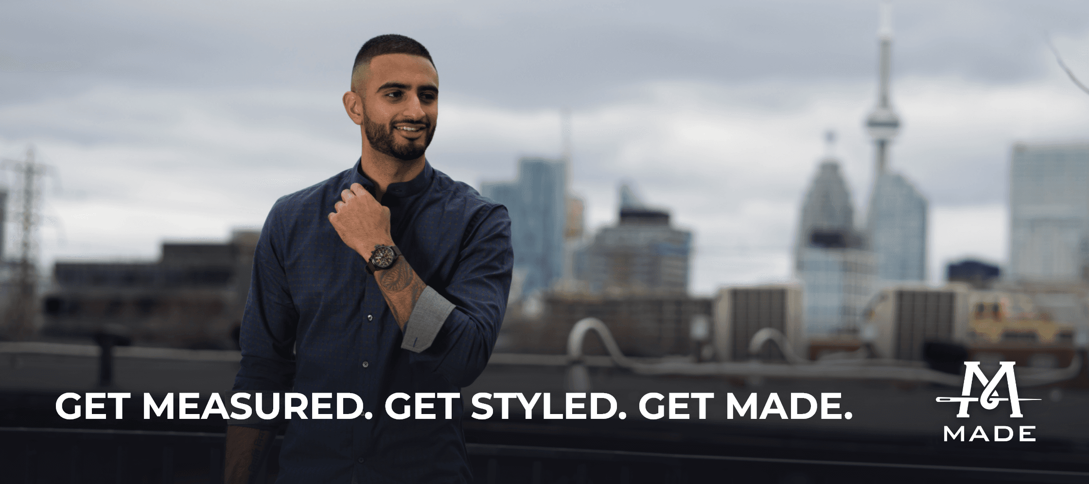 A stylish man wearing a casual dress shirt in front of a cityscape